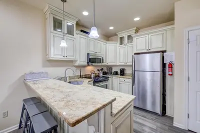 a kitchen with white cabinets and a stainless steel refrigerator at Pocono Retreat -1 Mile to Lake and Skiing! in Lake Harmony