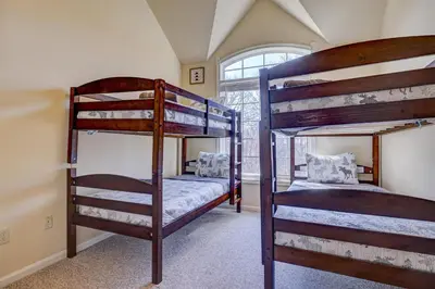 two bunk beds in a room with a window at Pocono Retreat -1 Mile to Lake and Skiing! in Lake Harmony