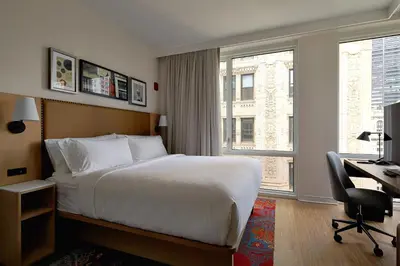 a hotel room with a bed and a desk and a window at Hotel Indigo NYC Financial District by IHG in New York