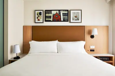a bedroom with a large white bed with three pictures on the wall at Hotel Indigo NYC Financial District by IHG in New York