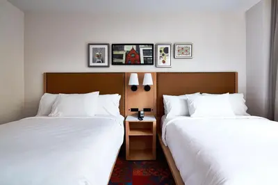two beds in a hotel room with white sheets at Hotel Indigo NYC Financial District by IHG in New York