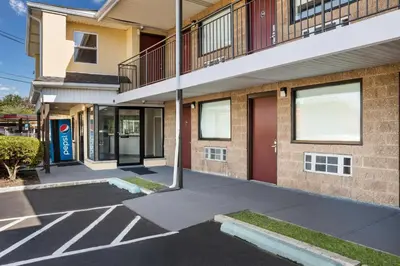 an apartment building with a parking lot in front of it at Red Carpet inn Edison in Edison