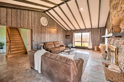 a living room with a couch and a stone wall at Quiet Elizabethville Home with Fire Pit and Views in Elizabethville