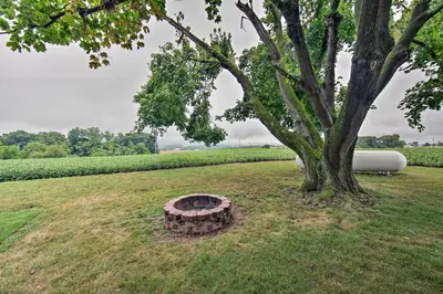 a tree and a fire pit in a field at Quiet Elizabethville Home with Fire Pit and Views in Elizabethville