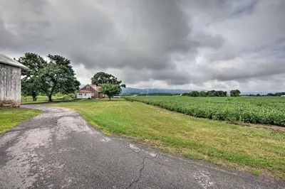 a dirt road leading to a farm house and a field at Quiet Elizabethville Home with Fire Pit and Views in Elizabethville
