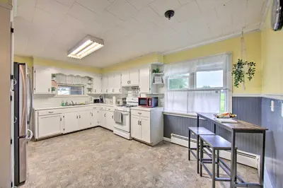 a kitchen with white appliances and a table in it at Quiet Elizabethville Home with Fire Pit and Views in Elizabethville