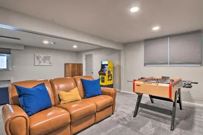 a living room with a brown leather couch and a table at Decked-Out Home Hot Tub, Pool, Fire Pit and More! in Monroe