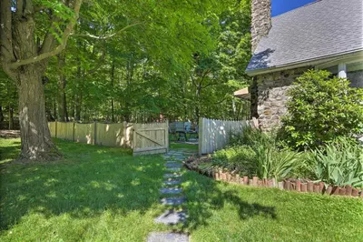 a garden with a stone path leading to a house at Decked-Out Home Hot Tub, Pool, Fire Pit and More! in Monroe
