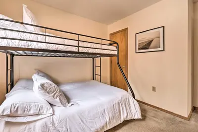 a bedroom with a bunk bed with white sheets and pillows at Walk to Arrowhead Lake Cabin with Private Hot Tub! in Pocono Lake