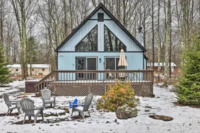 a blue house with chairs and a table in the snow at Walk to Arrowhead Lake Cabin with Private Hot Tub! in Pocono Lake