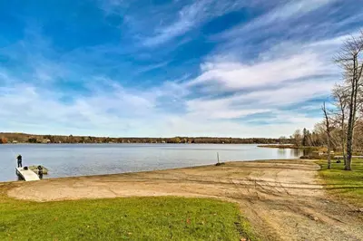 a person standing on the shore of a lake at Walk to Arrowhead Lake Cabin with Private Hot Tub! in Pocono Lake