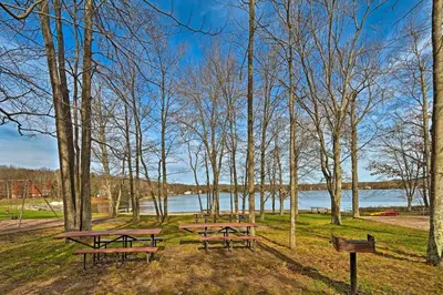 three picnic tables in a park near a lake at Walk to Arrowhead Lake Cabin with Private Hot Tub! in Pocono Lake