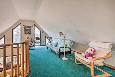 a living room with a doll sitting in a chair at Walk to Beach Lakefront Pocono Escape with Fire Pit in Pocono Lake