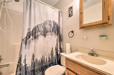a bathroom with a shower curtain with a toilet and a sink at Walk to Beach Lakefront Pocono Escape with Fire Pit in Pocono Lake