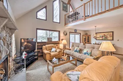 a living room with a couch and a tv at Walk to Beach Lakefront Pocono Escape with Fire Pit in Pocono Lake