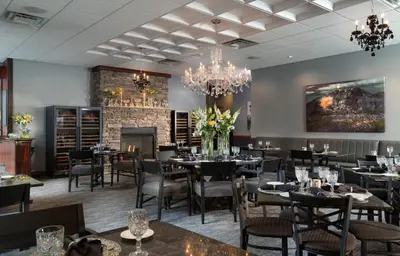 a dining room with tables and chairs and a chandelier at Hotel Anthracite in Carbondale