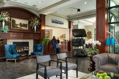 a lobby with a fireplace and chairs and a woman at Hotel Anthracite in Carbondale