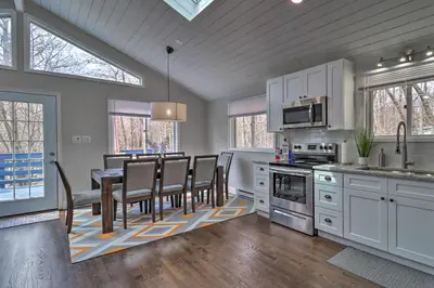 a kitchen with white cabinets and a table and chairs at 6 Mi to Camelback Slopes! Home with Game Room in Long Pond