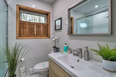 a bathroom with a sink and a toilet and a mirror at 6 Mi to Camelback Slopes! Home with Game Room in Long Pond