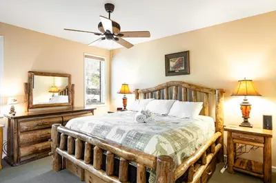a bedroom with a wooden bed and a ceiling fan at Kelto Kabin in Lake Harmony