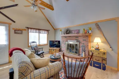 a living room with a couch and a fireplace at Walk to Beach Pocono Lake Cabin with Pool Access! in Pocono Lake