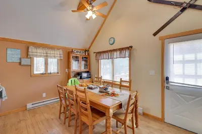 a dining room with a wooden table and chairs at Walk to Beach Pocono Lake Cabin with Pool Access! in Pocono Lake