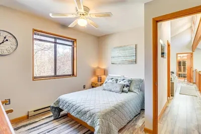 a bedroom with a bed and a clock on the wall at Private Spa, Fire Pit and Deck Poconos Home! in Long Pond