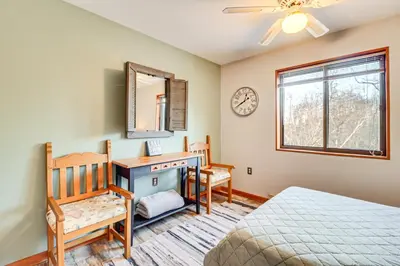 a bedroom with a bed and a desk and a mirror at Private Spa, Fire Pit and Deck Poconos Home! in Long Pond