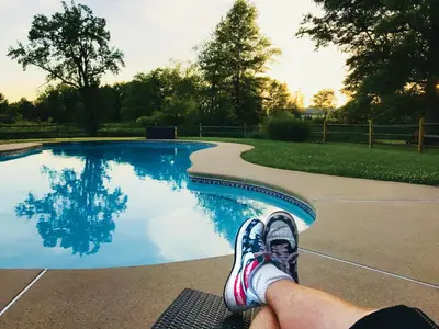 a person sitting on a bench next to a swimming pool at Galvanized America Inn & Art Gallery in Doylestown