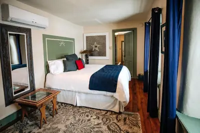 a bedroom with a bed and a mirror and a table at Galvanized America Inn & Art Gallery in Doylestown