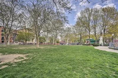 a park with green grass and trees and buildings at Hoboken Studio Near Dining about 15 Min to NYC! in Hoboken