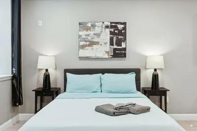 a bedroom with a bed with blue pillows and two lamps at Stay at Luna on Callowhill in Philadelphia
