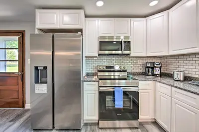 a kitchen with white cabinets and a stainless steel refrigerator at 1 Mi to Hersheypark Family Home with Game Room! in Hershey