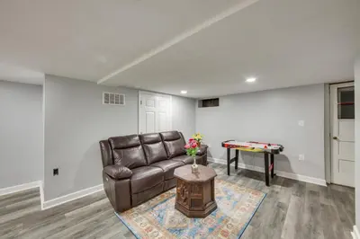 a living room with a leather couch and a table at 1 Mi to Hersheypark Family Home with Game Room! in Hershey