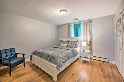 a bedroom with a bed and a chair at 1 Mi to Hersheypark Family Home with Game Room! in Hershey