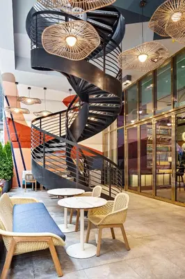 a spiral staircase in a restaurant with tables and chairs at Grayson Hotel in New York
