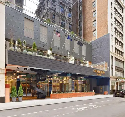 a building on a street with flags on a balcony at Grayson Hotel in New York