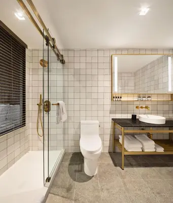 a bathroom with a toilet and a shower and a sink at Grayson Hotel in New York