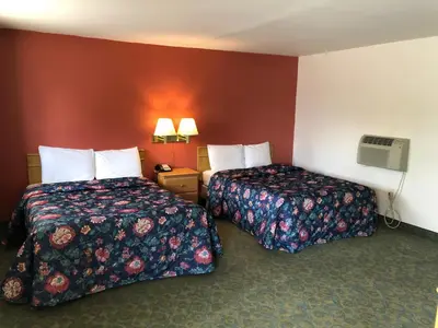 two beds in a hotel room with red walls at DEEPWELL MOTEL in Owego