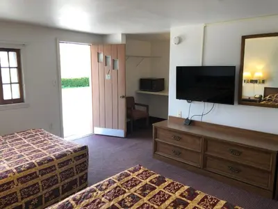 a hotel room with a bed and a flat screen tv at DEEPWELL MOTEL in Owego