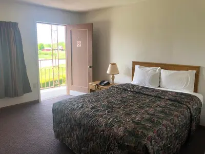 a hotel room with a bed and a window at DEEPWELL MOTEL in Owego