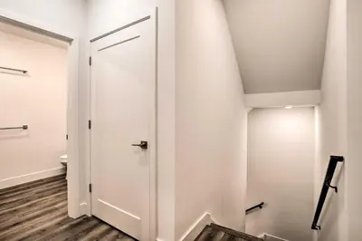 a bathroom with a white door and wooden floors at Trendy Apt with Laundry Machines Less Than 3 Mi to Dtwn in Philadelphia