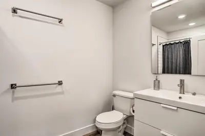 a white bathroom with a toilet and a sink at Trendy Apt with Laundry Machines Less Than 3 Mi to Dtwn in Philadelphia