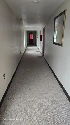 an empty hallway in an apartment with a red door at Stardust Motel in Duncannon
