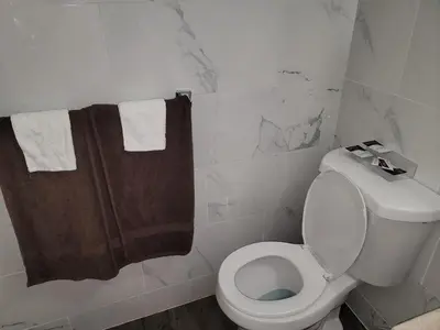 a bathroom with a white toilet and a brown towel at Stardust Motel in Duncannon