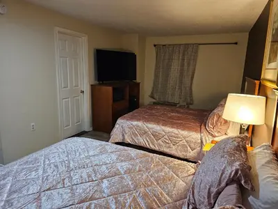 a hotel room with two beds and a flat screen tv at Stardust Motel in Duncannon