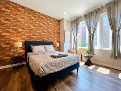 a bedroom with a brick wall and a bed at Stay at Luna on Ridge Ave in Philadelphia