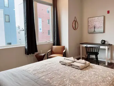 a bedroom with a bed and a table and a window at Stay at Luna on Ridge Ave in Philadelphia