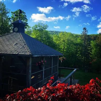 a small building with a clock tower on top of it at The Blue House On The Hill Catskills—Views in Claryville
