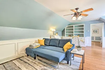 a blue couch in a living room with a ceiling fan at Pet-Friendly Pond View Loft with Private Pool! in Walden